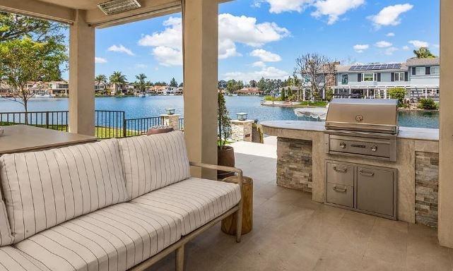 Covered outdoor kitchen and waterfront patio designed for indoor-outdoor living