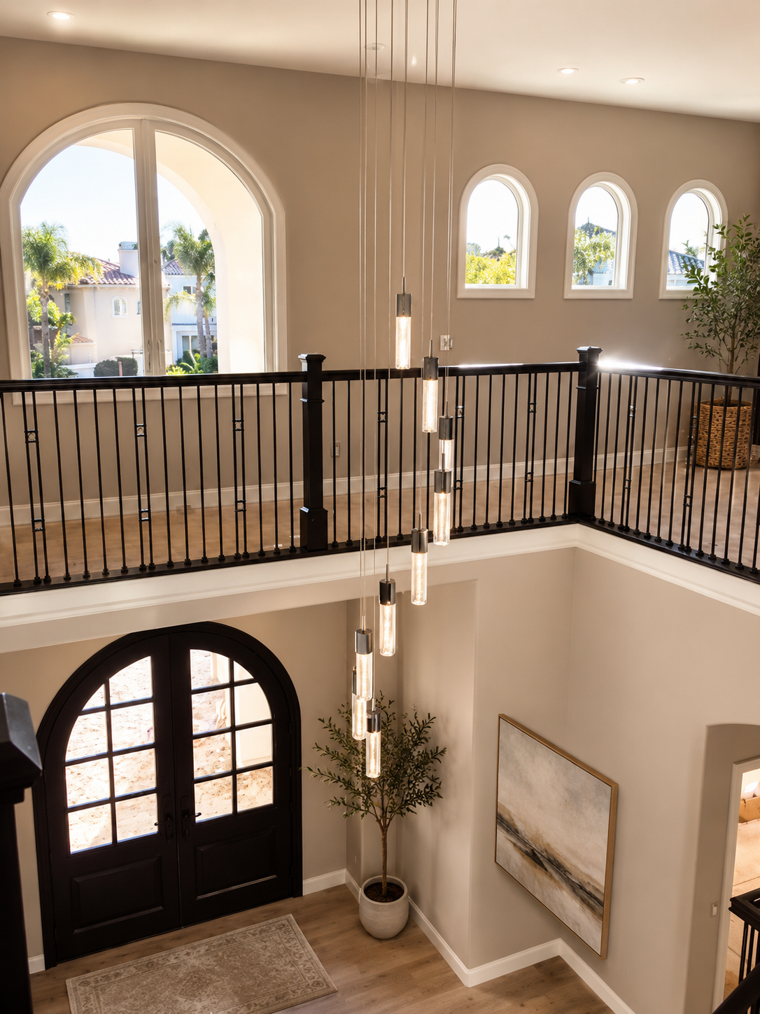 Grand custom home entry with arched windows, pendant lighting, and refined architectural details